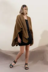 Ruana tejida en algodón color beige, con terminaciones de crochet color naranja. Diseño con mezcla de puntos y combinación de colores.