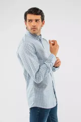 Camisa de manga larga con diseño de cuadros en tonos azules, blancos y negros. Presenta cuello clásico, cierre frontal con botones y logo bordado en el pecho. Corte semi slim.