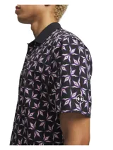 Polo de golf de manga corta con tecnología UA Helix, diseñado para absorber la humedad y optimizar la ventilación. Presenta un estampado geométrico en tonos oscuros con detalles en lila, cuello estructurado con varillas integradas y tapeta termosellada.