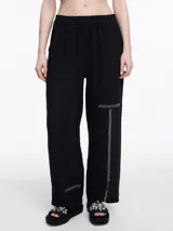 Pantalón de lino 100% color negro, con cintura elástica y calce relajado. Incluye bolsillos laterales y un bolsillo invertido. Los detalles de bordado tipo pespunte en color contraste recorren la pier pierna y el bajo.