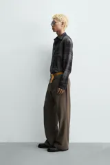 Pantalón de corte flare fit confeccionado en una mezcla de viscosa y lino. Presenta bolsillos delanteros, bolsillos traseros de vivo, cierre frontal con cremallera y gancho metálico oculto.