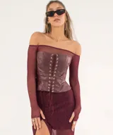 Corset strapless color amarillo pálido con cordones negros en el frente y en los laterales.