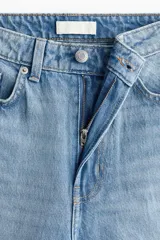 Jean de tiro alto con cinco bolsillos, confeccionado en denim de algodón rígido en color celeste claro, de piernas amplias y corte holgado con terminación recta.