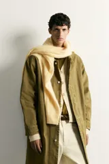 Parka relaxed fit confeccionada en denim de algodón color verde militar, con cuello solapa, bolsillos de vivo en la cadera y cierre frontal con cremallera oculta por solapa con botones a presión.