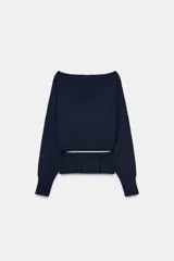 Jersey de punto color mostaza con cuello barco, manga larga con sisa ancha y detalle de cinturón fino integrado en la cintura.