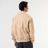 Campera de twill beige con cierre frontal, cuello camisero, bolsillos laterales con solapa y puños y cintura elastizados de rib.