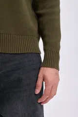Sweater de punto color verde oliva, con cuello redondo y mangas largas. Diseño clásico con terminaciones acanaladas en cuello, puños y ruedo.