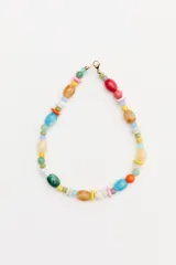 Collar corto de cuentas multicolor de formas y tamaños variados, con cierre metálico dorado.