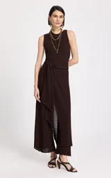 Pantalón de punto color chocolate, de corte recto y tiro alto. Presenta una superposición frontal cruzada con lazo lateral en la cintura, textura tejida con ligera transparencia en el dobladillo y detalle de ribete de encaje en la parte inferior.