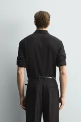 Camisa de corte relajado confeccionada en una mezcla de lana y viscosa. Presenta cuello clásico, manga larga con puños abotonados y cierre frontal con botones a tono.