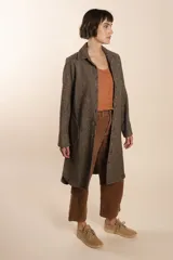 Camisa larga color beige con botones dorados y bolsillo plaque en la delantera. Confeccionada en lana fina sin teñir, diseñada exclusivamente por Don Baez. Hecha 100% en Uruguay.