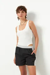 Short deportivo negro de nylon con cintura elástica, detalles en gris y bolsillos laterales.