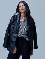 Blazer de eco cuero negro con corte oversized, cuello con solapa, cierre frontal con botones y bolsillos delanteros aplicados.
