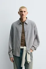 Sobrecamisa de corte relajado confeccionada en tejido de algodón con diseño de cuadros. Presenta cuello solapa, cierre frontal de botones y mangas largas con puños abotonados.