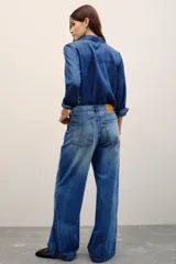 Pantalón jean de corte wide leg y tiro medio, en color azul clásico con efecto desteñido.