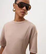 Blusa Cortelle de modal color beige, con corte peplum, cuello redondo, mangas cortas y recortes estruturados que marcan la cintura.