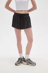 Short de poliéster color celeste, de calce holgado y tiro alto, con cintura elástica ajustable mediante cordón y bolsillos laterales.
