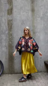 Falda midi evasé de raso color negro, con cintura elástica y cinturón con apliques metálicos.