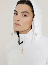 Campera blanca acolchada con cierre de cremallera, cuello alto con capucha, mangas largas y bolsillos laterales con cremallera.