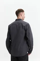 Camisa manga larga color verde oliva, corte slim fit, con cartera abotonada, dos bolsillos frontales con botón y confeccionada en 100% algodón.