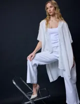 Kimono de gasa color blanco, con diseño abierto y mangas amplias. Presenta detalles de apliques brillantes a lo largo de la abertura frontal.