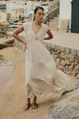 Maxi vestido color beige melange, con escote en V, mangas cortas y falda larga con volantes.