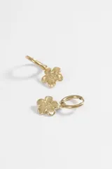 Aros argollas de acero quirúrgico plateado con dije colgante en forma de flor texturada.