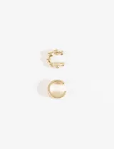Set de dos earcuffs metálicos dorados, uno con diseño de tres aros lisos superpuestos y otro con diseño de esferas pequeñas unidas.