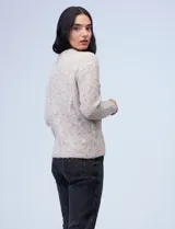 Buzo de lana melange color tostado, con cuello redondo y mangas largas.