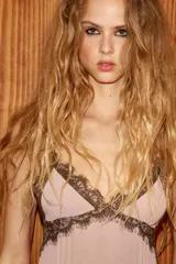 Vestido corto de escote en pico con tirantes finos ajustables, confeccionado en tejido liso con detalles de encaje a contraste en el escote y el ruedo. Presenta un diseño con falda con volado y cierre posterior con cremallera oculta.