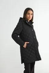 Campera acolchada negra con diseño de rombos, cierre frontal con cremallera y botones a presión, y capucha integrada.