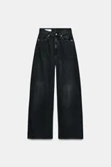 Jeans de mezclilla en color negro gastado, tiro alto, diseño de cinco bolsillos y corte de pierna ancha extra larga. Cuenta con cierre frontal de cremallera y botón metálico.