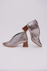 Botines de cuero color beige con diseño de tajo frontal, punta fina y taco cuadrado de madera.