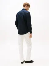 Camisa de manga larga Tommy Hilfiger color azul marino, de corte regular, confeccionada en popelina elástica de algodón regenerativo, algodón BCI y elastano. Presenta cuello clásico, cierre con botones, puños abotonados y logo bordado en el pecho.