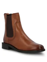 Botín estilo Chelsea color suela, confeccionado en cuero con paneles elásticos laterales en color marrón oscuro. Presenta punta redonda, taco cuadrado bajo y suela de goma.