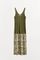 Vestido midi de punto acanalado color verde oliva, con escote en V y tirantes anchos. La parte superior presenta un diseño de tejido rib, mientras que la parte inferior está terminada con una aplicación de encaje transparente al tono.