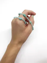 Collar corto de cuentas de piedra en tonos turquesa y celeste, con diseño de piedras facetadas y cuentas irregulares intercaladas.