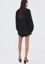 Blusa Lucy de diseño recto color negro, confeccionada en mezcla de algodón y viscosa. Cuenta con cuello mao, detalles bordados calados, manga larga y cierre frontal con botones.
