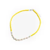Collar corto de cuentas amarillas con detalle central de perlas blancas y cuentas doradas.