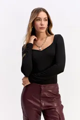 Body de manga larga color negro, con escote cuadrado pronunciado y ajuste al cuerpo.