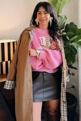 Sweater tejido de punto en color rosado, con diseño de bota estilo western en el frente y detalles de estrellas pequeñas en color rojo. Presenta cuello redondo, mangas largas abullonadas y puños acanalados.