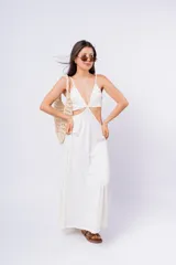 Vestido largo blanco con escote en V, abertura en la cintura y breteles finos.