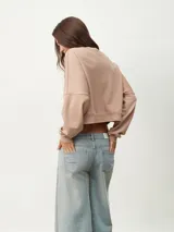 Buzo manga larga color celeste con diseño irregular y corte crop.