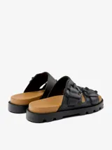 Sandalias negras con plataforma y dos tiras anchas con hebillas decorativas. Suela color caramelo y base negra con diseño antideslizante.