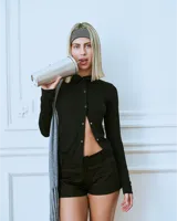 Top manga larga negro confeccionado en rayón con hilera de botones broche asimétricos.