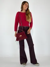 Cartera bandolera color borgoña de gamuza con flecos y cierre metálico dorado.