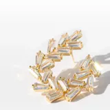 Par de aros grandes dorados con cristales claros rectangulares.