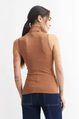 Chaleco negro de punto con cuello alto y sisas amplias.