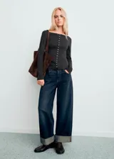 Cardigan de punto fino color gris oscuro, con cuello barco, diseño entallado, manga larga y cierre frontal de botones pequeños.