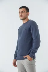 Sweater de punto color ladrillo, con cuello redondo y logo bordado en el pecho.